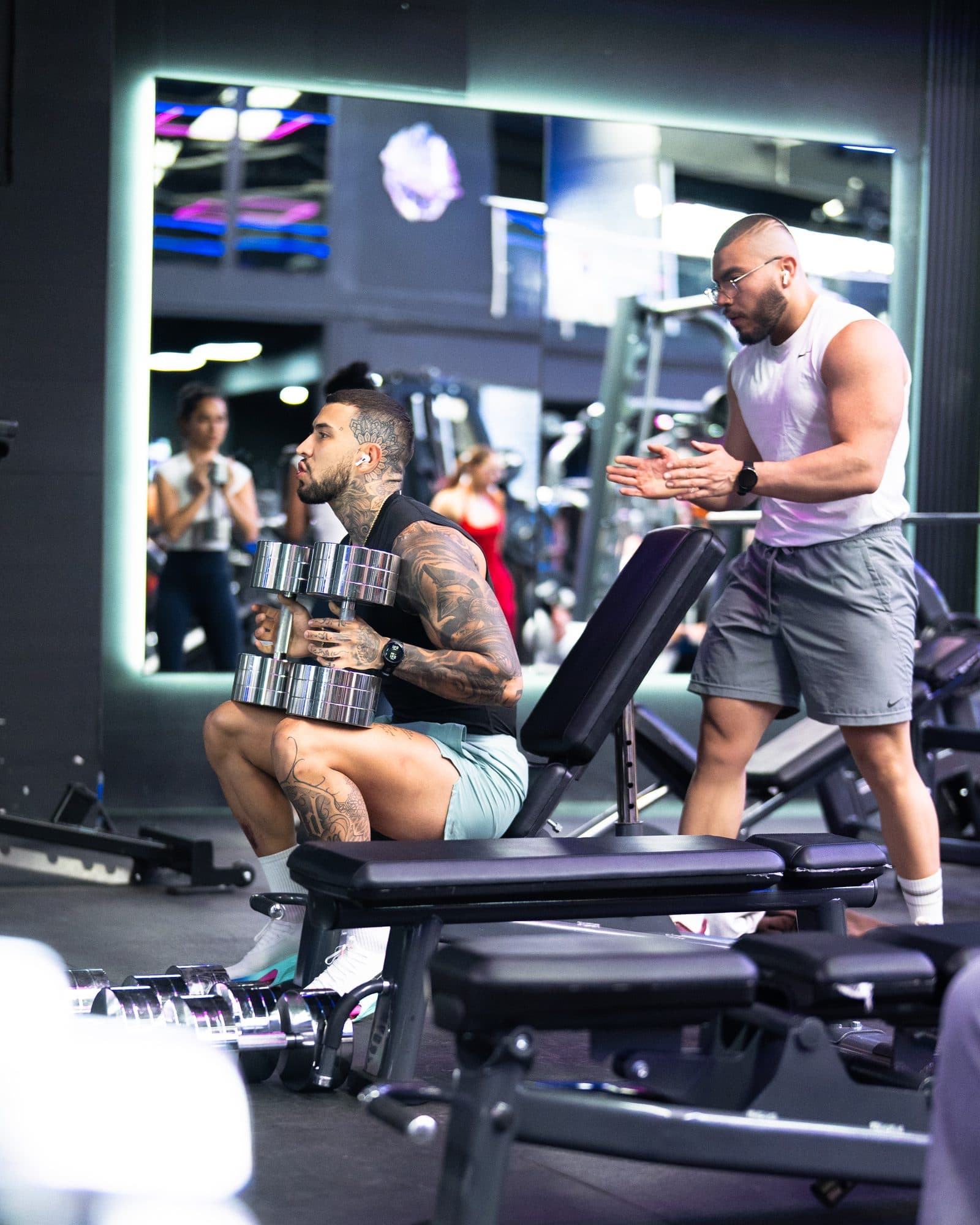 Marco corrigiendo la ejecución de un cliente en el gimnasio